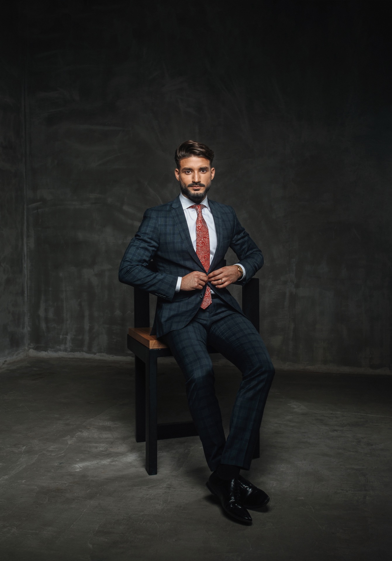 brunette handsome man in a suit on a dark background